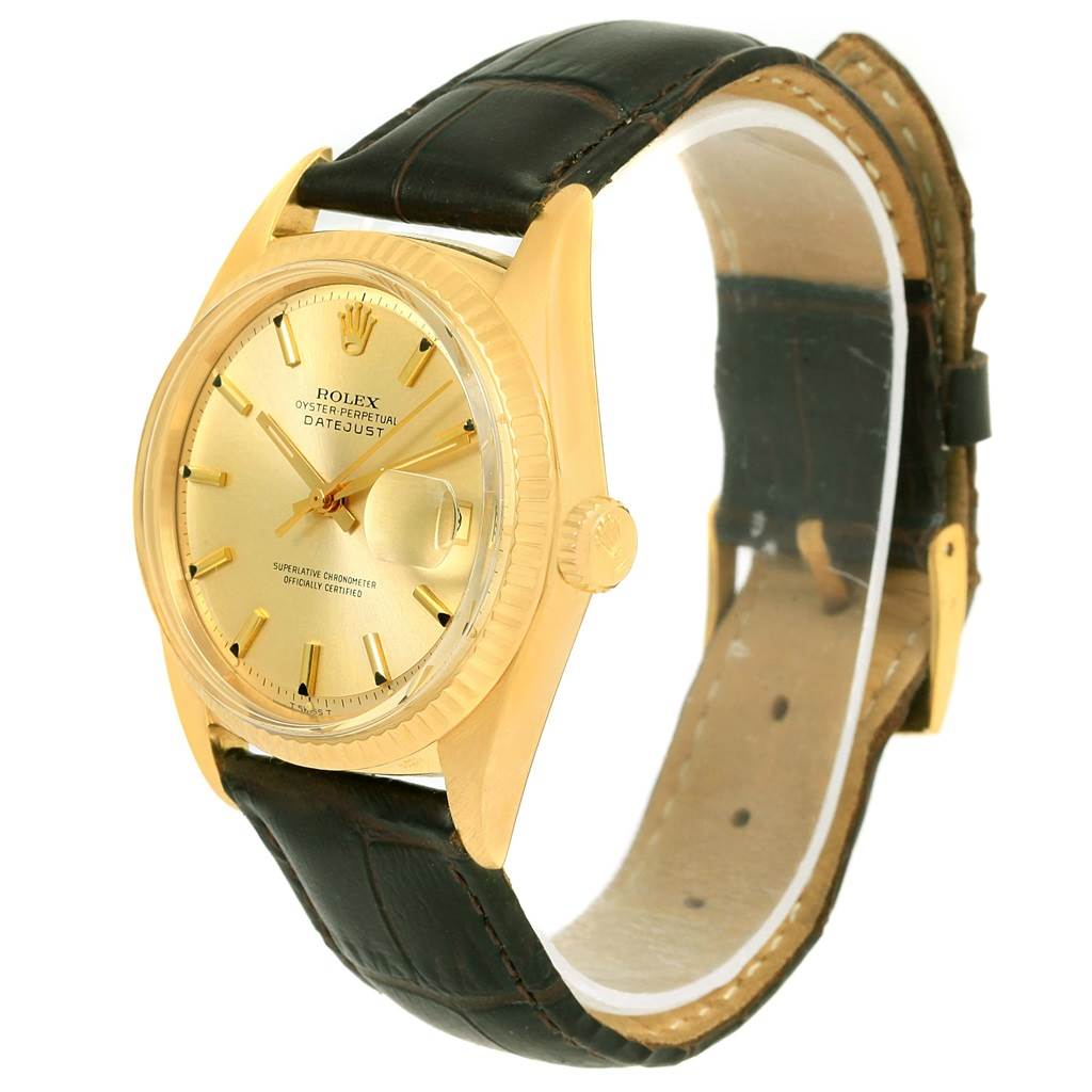 The image shows a side angle of a Rolex Vintage Collection 1601 Men's Yellow Gold Champagne Dial 1601 Men's Yellow Gold Champagne Dial Datejust watch, highlighting its gold case, bezel, and leather strap.