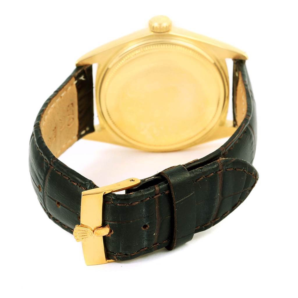 The image shows the back view of a Vintage Collection Rolex watch, highlighting its gold case and dark leather strap.