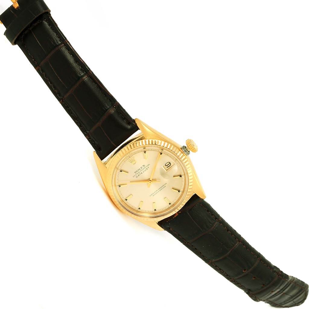 The Rolex Vintage Collection 1601 Men's Yellow Gold Champagne Dial 1601 Men's Yellow Gold Champagne Dial watch is shown at a slight diagonal angle, displaying its dial, gold case, crown, and leather strap.