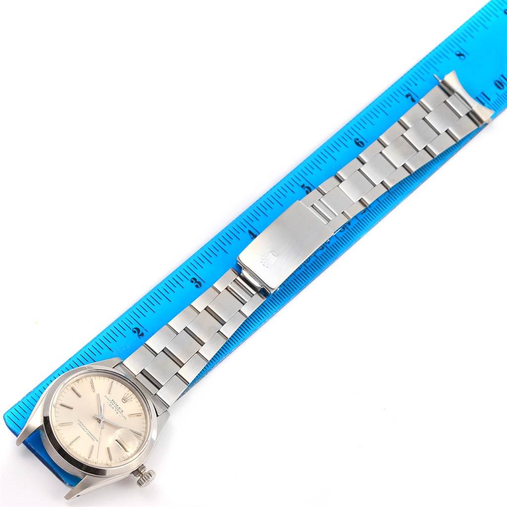 The Rolex Vintage Collection 1500 Men's Stainless Steel Silver Dial 1500 Men's Stainless Steel Silver Dial watch is shown fully extended, placed beside a blue ruler for scale.