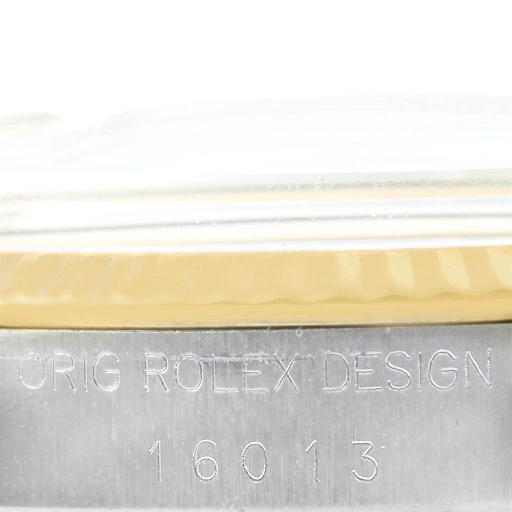 This image shows a close-up of the side of a Rolex Vintage Collection 16013 Men's Stainless Steel Champagne Dial 16013 Men's Stainless Steel Champagne Dial watch, highlighting its bezel and engraved design details.