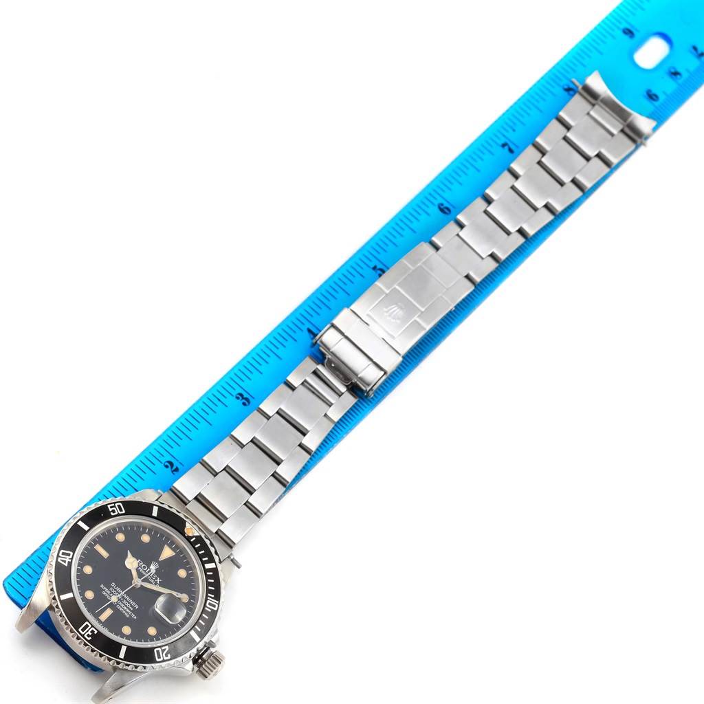 The Rolex Vintage Collection 16800 Men's Stainless Steel Black Dial 16800 Men's Stainless Steel Black Dial model watch is shown flat with its face and metal bracelet, next to a blue ruler.