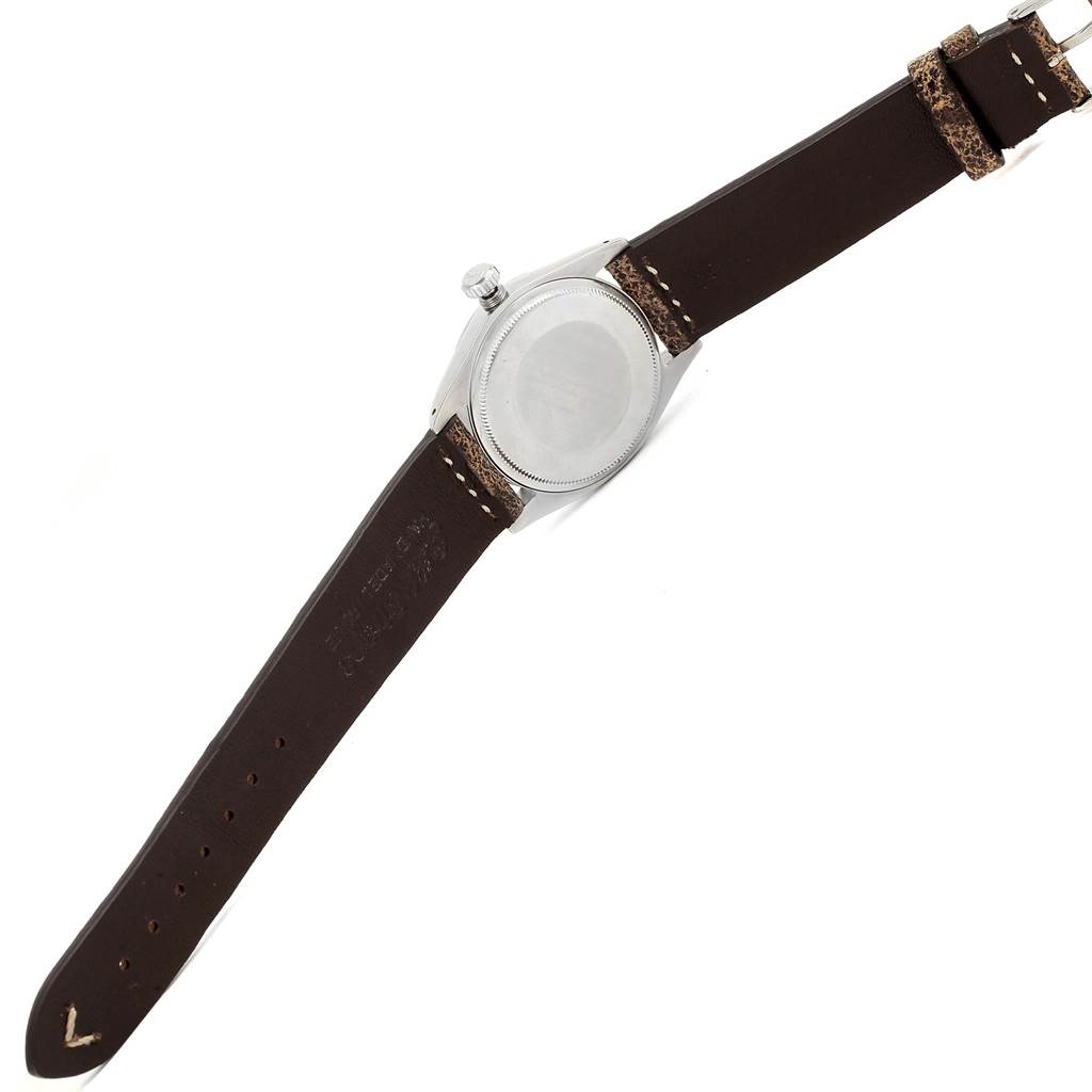 This photo shows the back case and brown leather strap of a Vintage Collection model by Rolex from an angled view.