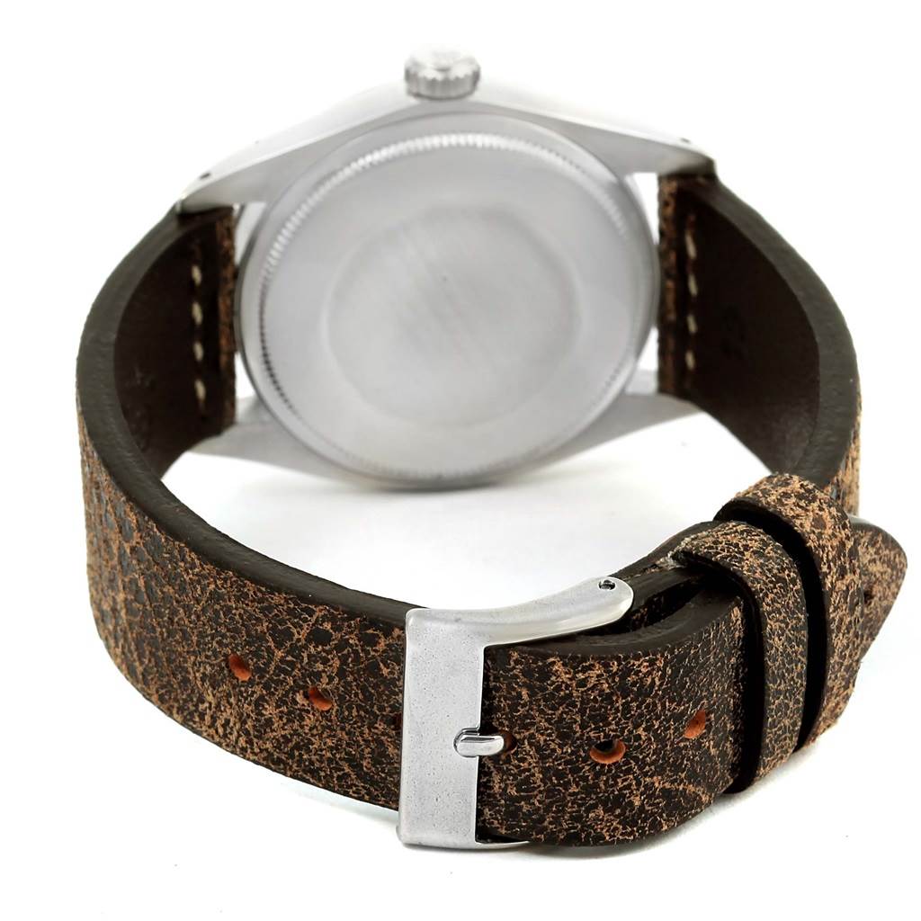 The Rolex Vintage Collection 1500 Men's Stainless Steel Silver Dial 1500 Men's Stainless Steel Silver Dial watch is shown from the back, highlighting its case back, crown, and distressed leather strap with a buckle.