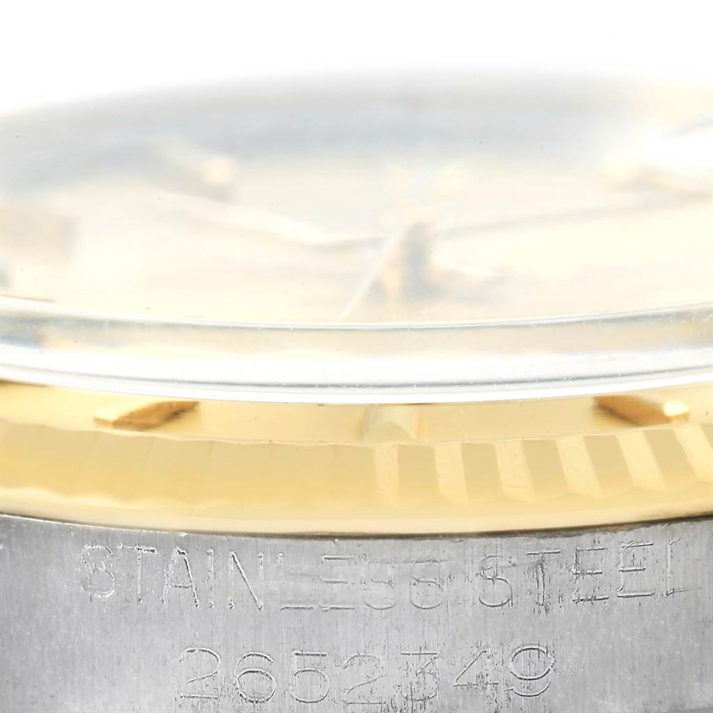 This close-up image of a Rolex Vintage Collection 1601 Men's Steel and Gold (two tone) Champagne Dial 1601 Men's Steel and Gold (two tone) Champagne Dial watch shows the side of the casing with engravings and part of the dial under the crystal.