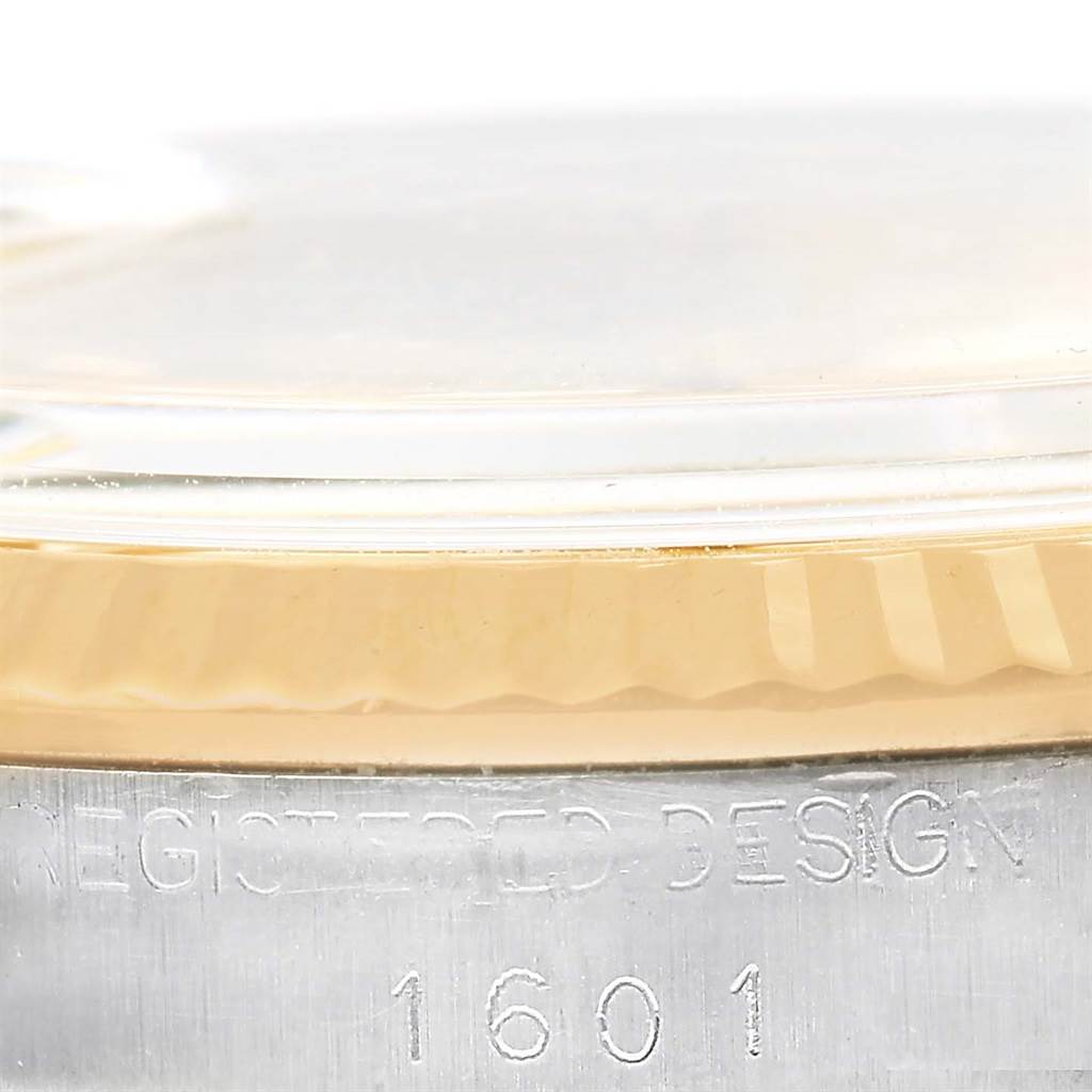 This image shows a close-up of the bezel, case, and part of the crystal of the Rolex Vintage Collection 1601 Men's Steel and Gold (two tone) Champagne Dial 1601 Men's Steel and Gold (two tone) Champagne Dial model, highlighting the engraving.