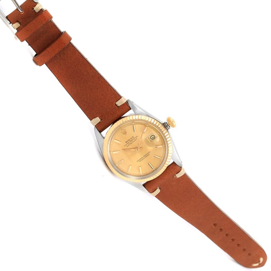 The Rolex Vintage Collection 1601 Men's Steel and Gold (two tone) Champagne Dial 1601 Men's Steel and Gold (two tone) Champagne Dial watch is shown from a top-down angle, highlighting the face, crown, and brown leather strap.