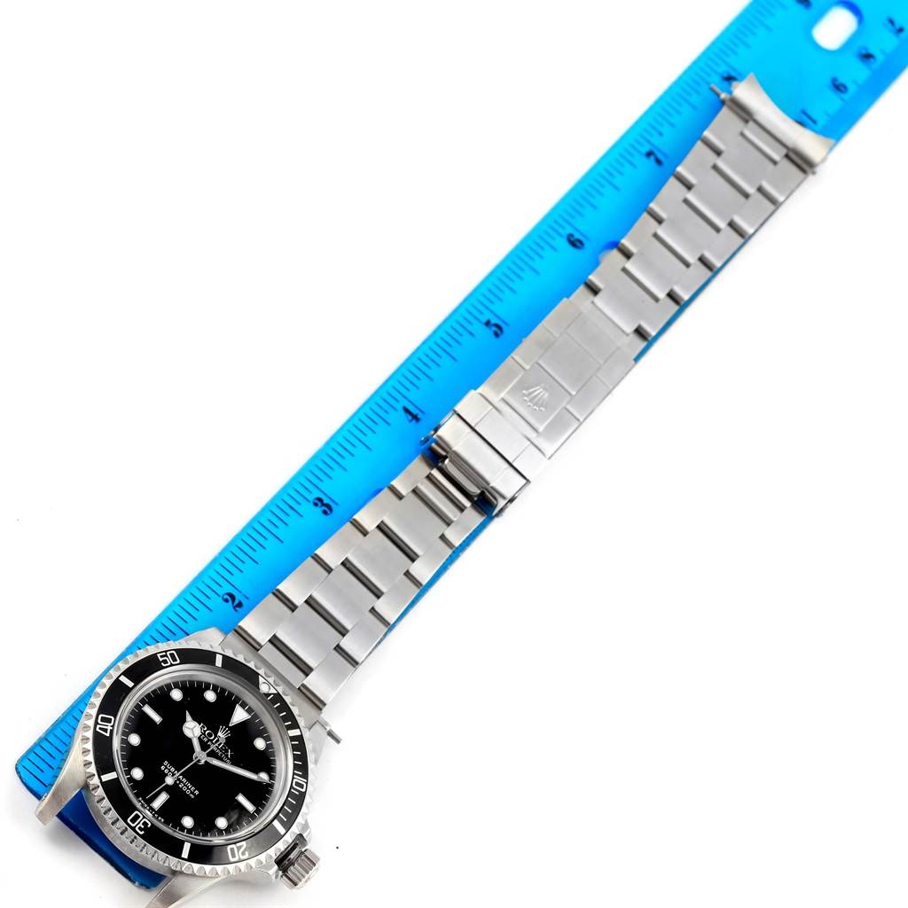 The Rolex Vintage Collection 5513 Men's Stainless Steel Black Dial 5513 Men's Stainless Steel Black Dial watch is shown lying flat with its face, bezel, and stainless steel bracelet fully visible, beside a ruler.