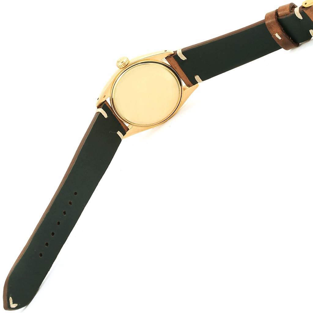 The image shows a Rolex Vintage Collection 6537 Men's Yellow Gold Champagne Dial 6537 Men's Yellow Gold Champagne Dial watch from the back, highlighting its gold case, crown, and leather strap.