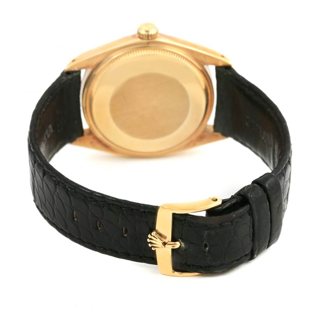 The image shows the case back and black leather strap of the Vintage Collection model by Rolex from a rear angle.