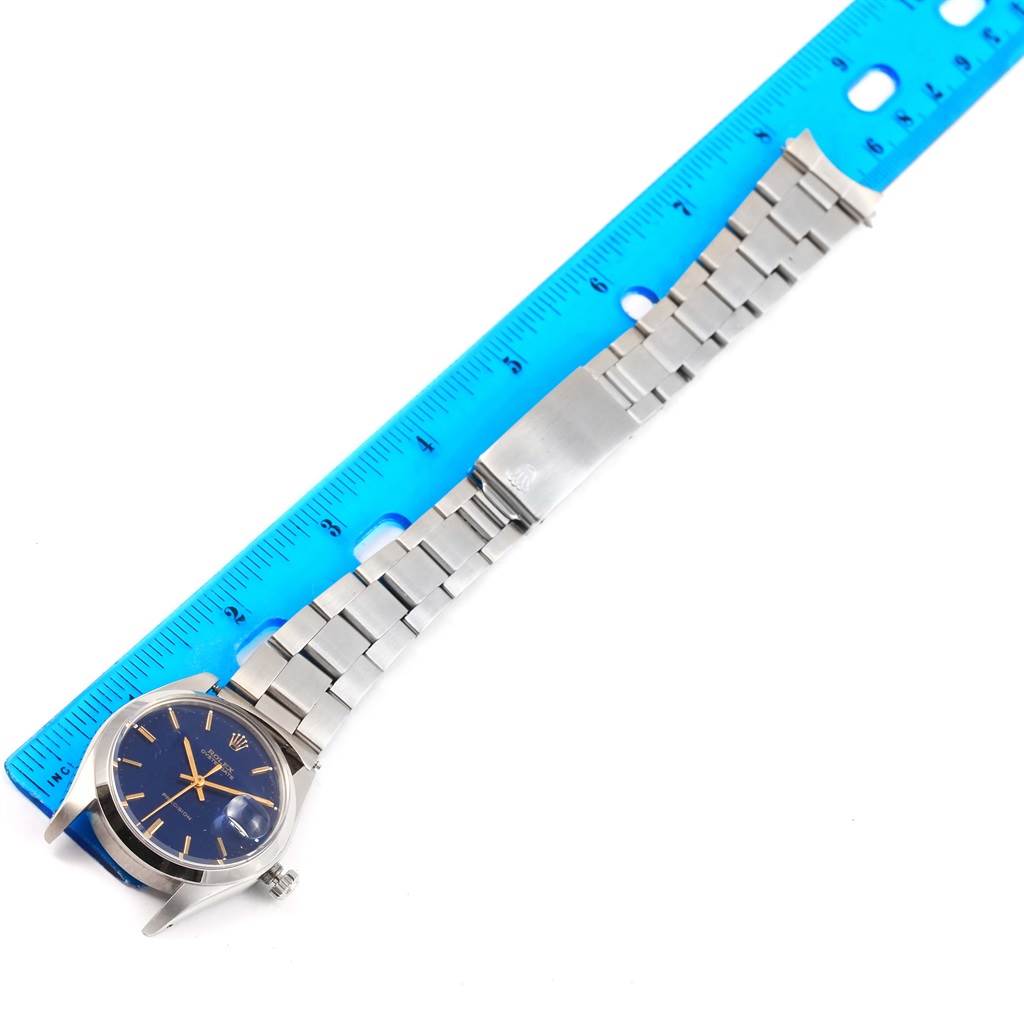 The Vintage Collection Rolex watch is shown flat with its bracelet extended next to a blue ruler.