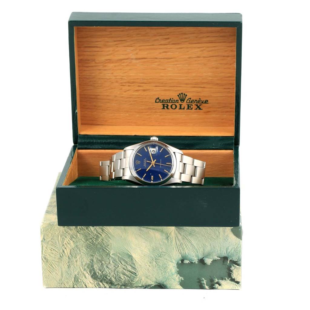 The Rolex Vintage Collection 6694 Men's Stainless Steel Blue Dial 6694 Men's Stainless Steel Blue Dial watch is shown from the front, placed inside its wooden box with a blue dial and metal bracelet visible.