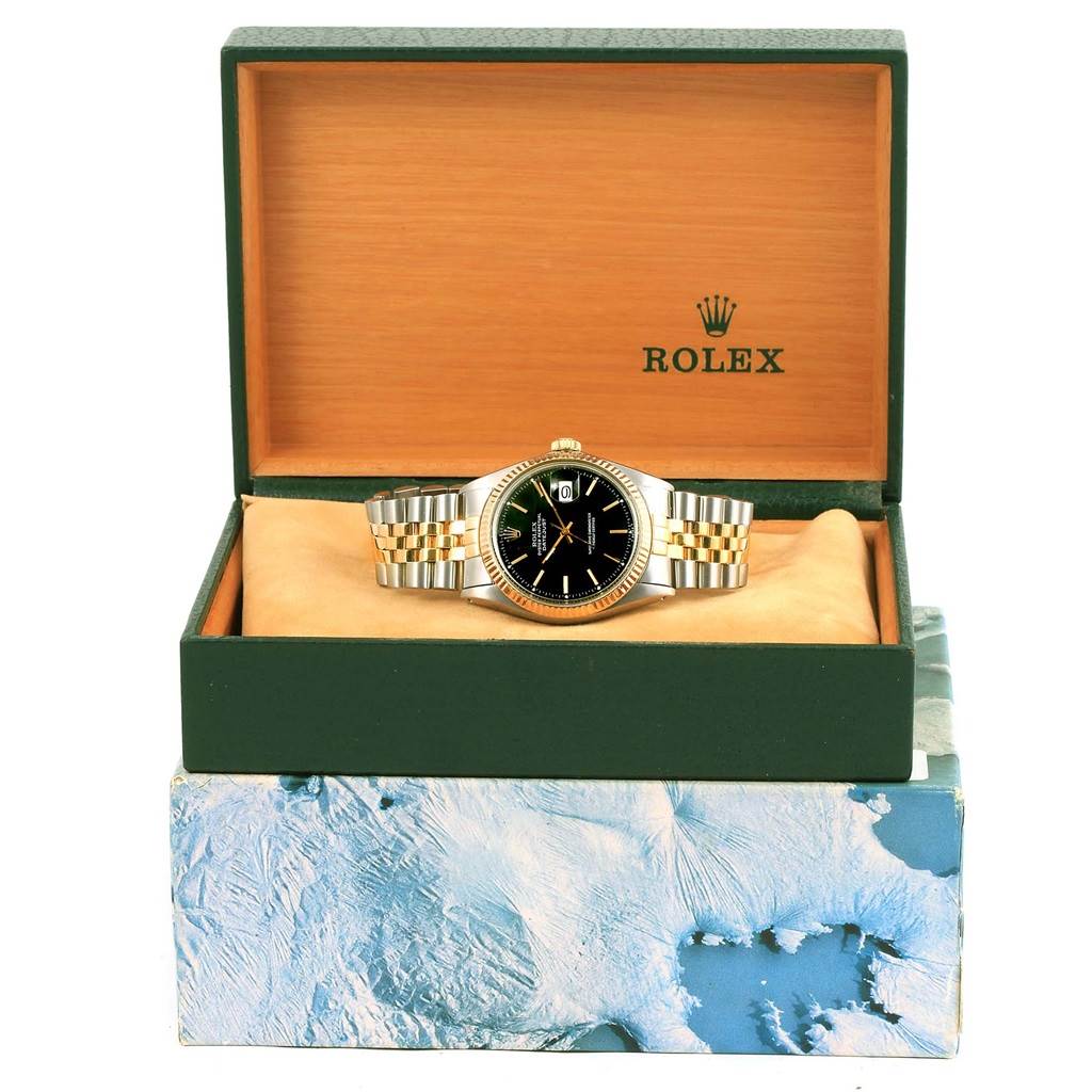 The Rolex Vintage Collection 1603 Men's Steel and Gold (two tone) Black Dial 1603 Men's Steel and Gold (two tone) Black Dial watch is shown from the front, inside an open green and wooden box, revealing the face and bracelet.