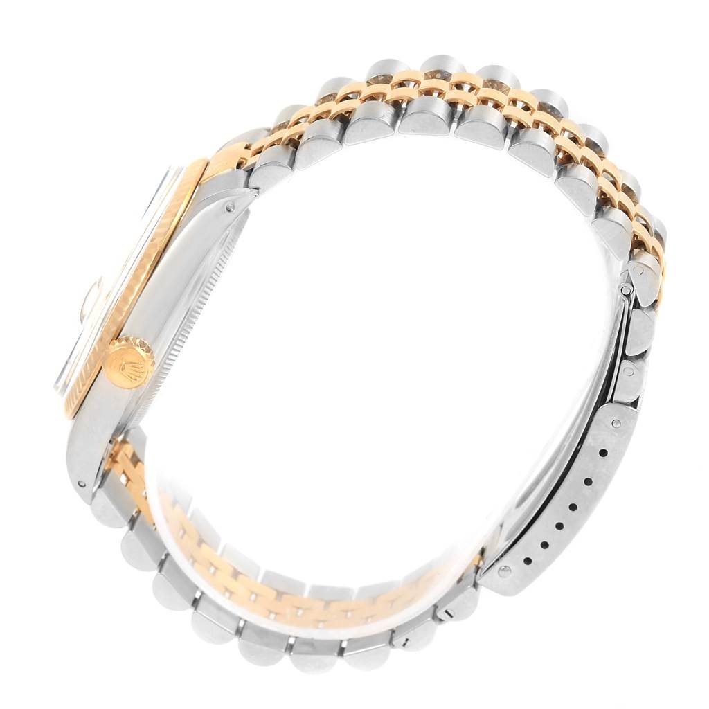 This side-angle view of the Rolex Vintage Collection 16013 Men's Stainless Steel Champagne Dial 16013 Men's Stainless Steel Champagne Dial watch shows the crown, case, and two-tone bracelet.