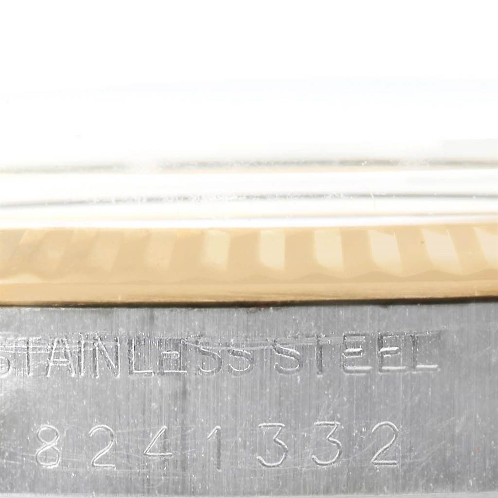 This close-up image of the Vintage Collection Rolex watch shows the bezel and part of the stainless steel case with the serial number.