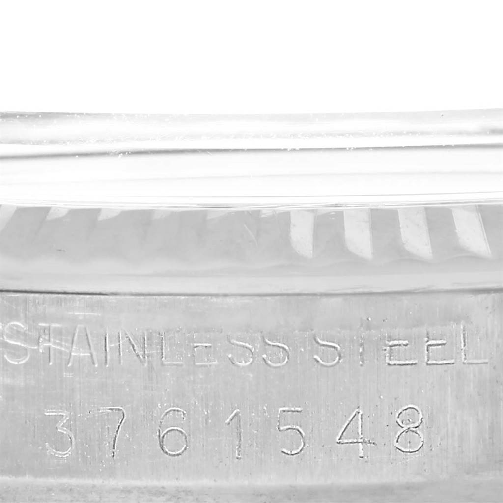 This close-up image shows the side of the Rolex Vintage Collection 1601 Men's Stainless Steel Silver Dial 1601 Men's Stainless Steel Silver Dial watch with the "Stainless Steel" engraving and serial number.