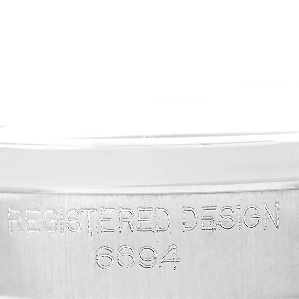 This image shows a close-up of the case side, focusing on the "Registered Design 6694" engraving of a Rolex Vintage Collection 6694 Men's Stainless Steel Silver Dial 6694 Men's Stainless Steel Silver Dial model.