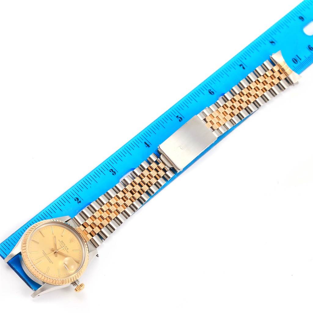 The image shows a Rolex Vintage Collection 15053 Men's Steel and Gold (two tone) Champagne Dial 15053 Men's Steel and Gold (two tone) Champagne Dial watch with a close-up of its dial, bezel, and full linked bracelet next to a blue ruler.