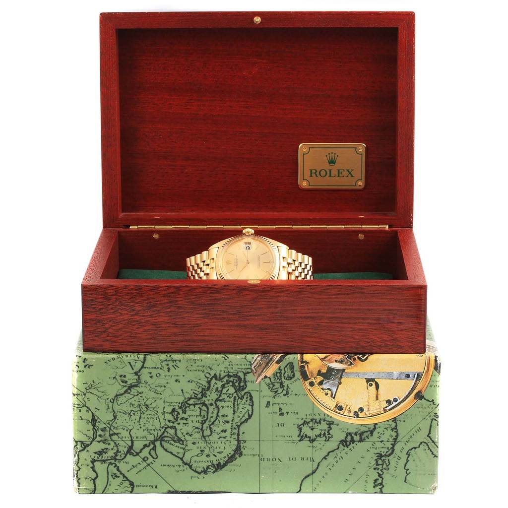 The Vintage Collection model by Rolex is shown from the front, placed inside an open wooden box with a map design on the exterior.