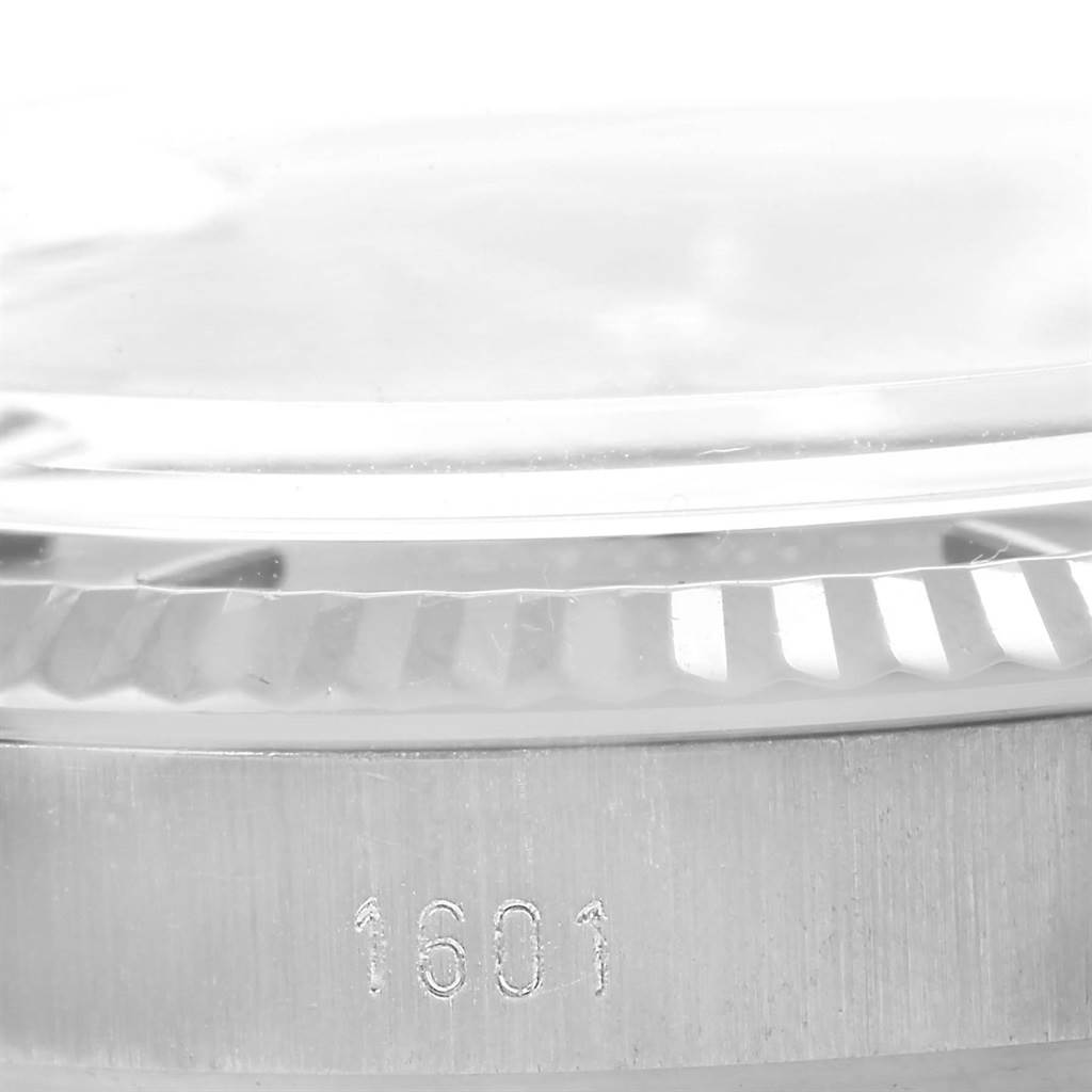 The image shows a close-up of the brushed metal case and bezel with grooves, along with the model number 1601, of a Rolex Vintage Collection 1601 Men's Stainless Steel Grey Dial 1601 Men's Stainless Steel Grey Dial watch.