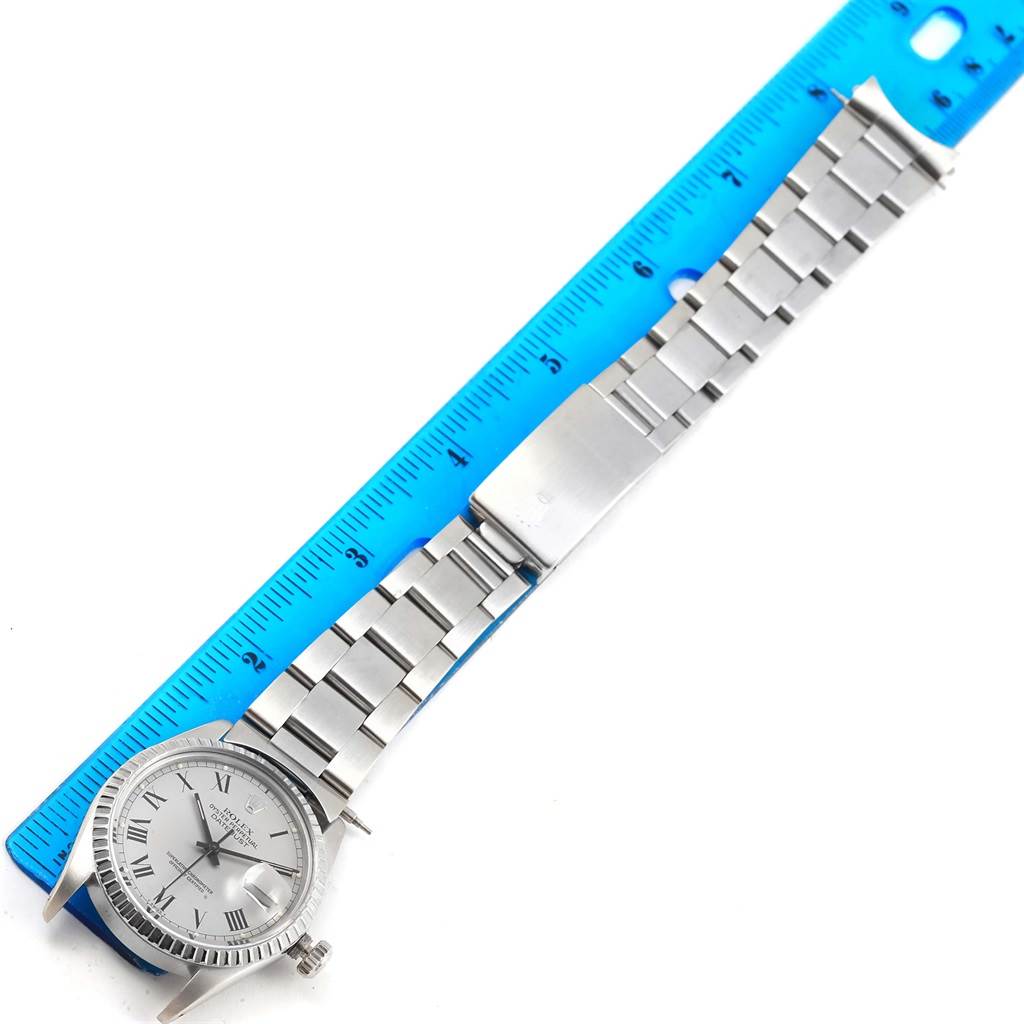 The image shows a Rolex Vintage Collection 16030 Men's Stainless Steel Grey Dial 16030 Men's Stainless Steel Grey Dial model watch laid flat next to a ruler, highlighting the watch's band, clasp, and face.