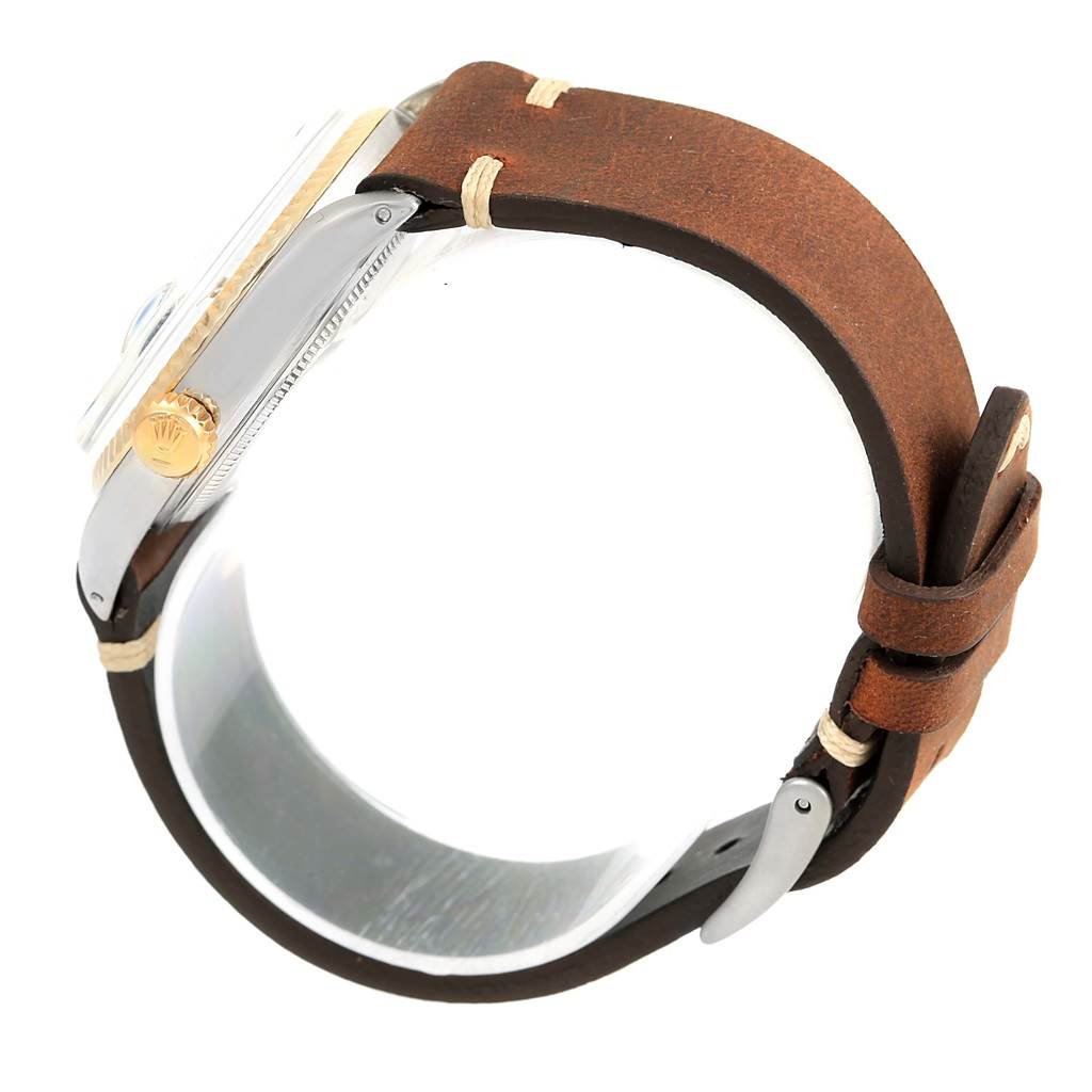 This image shows a side view of the Rolex Vintage Collection 1601 Men's Steel and Gold (two tone) Blue Dial 1601 Men's Steel and Gold (two tone) Blue Dial watch, highlighting the crown and brown leather strap.