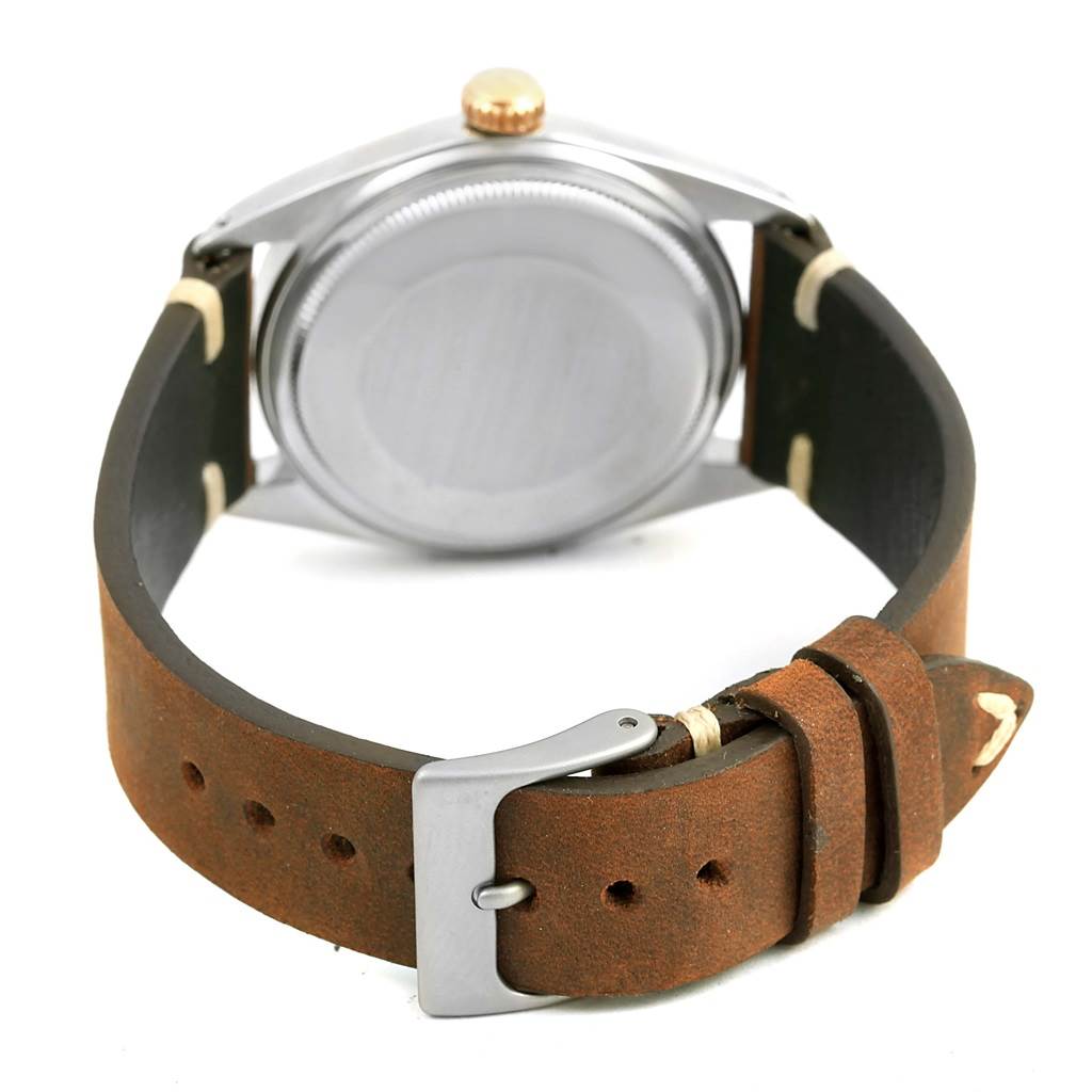 The image shows the back view of a Rolex Vintage Collection 1601 Men's Steel and Gold (two tone) Blue Dial 1601 Men's Steel and Gold (two tone) Blue Dial model watch with a brown leather strap and buckle.