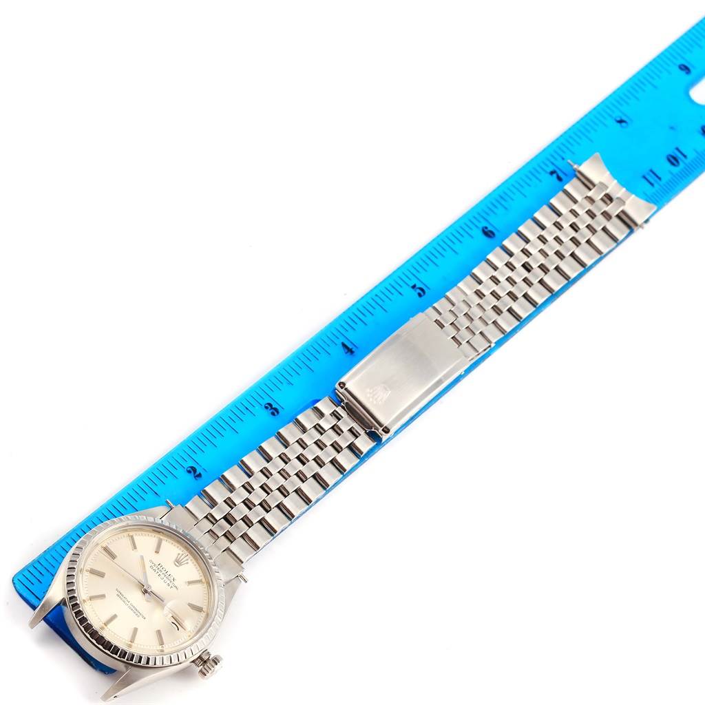 The image shows a flat-lay view of a Vintage Collection Rolex watch, highlighting its face, bracelet, and clasp next to a blue ruler.