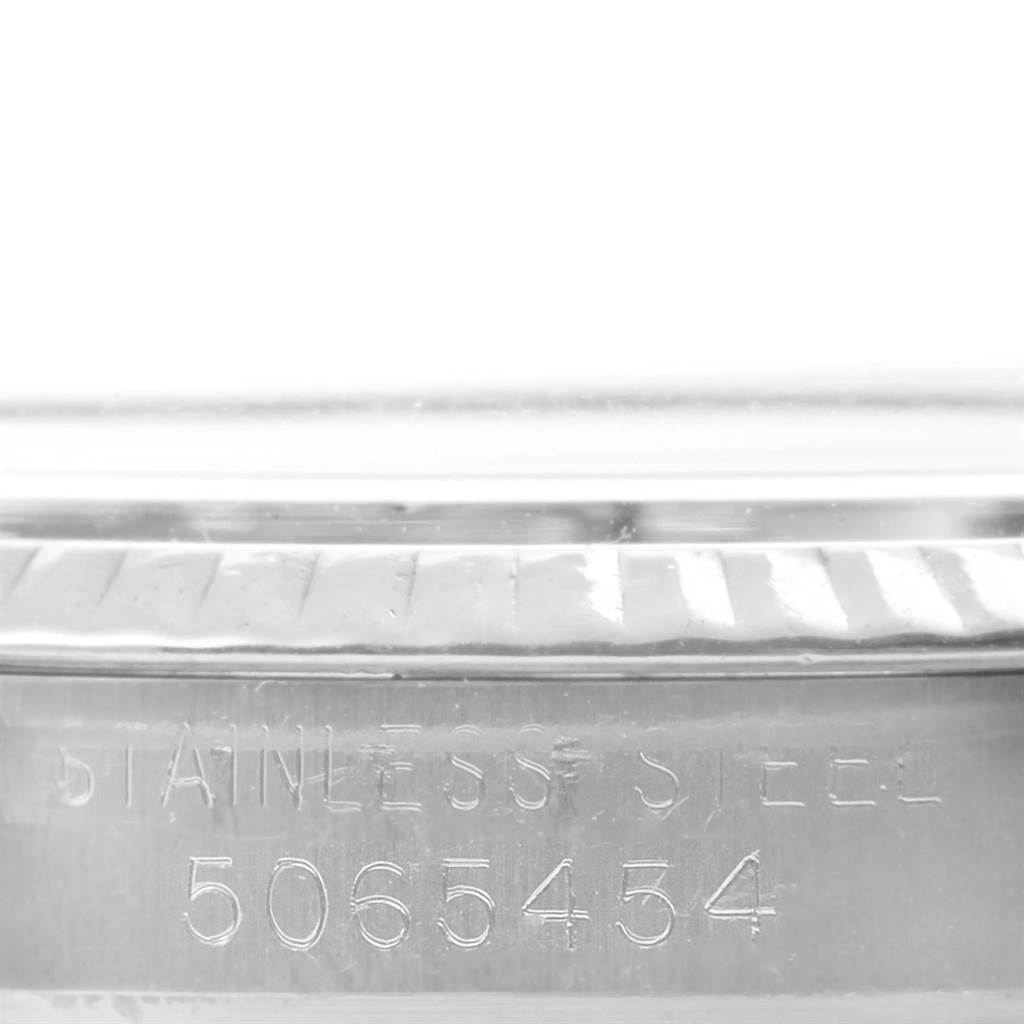 This image shows a close-up of the side of the case of a Rolex Vintage Collection 1601 Men's Stainless Steel Silver Dial 1601 Men's Stainless Steel Silver Dial watch, highlighting the serial number and "Stainless Steel" engraving.