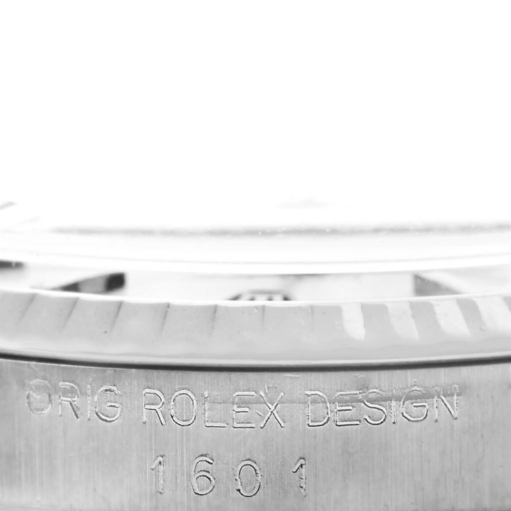 The image shows a close-up of the side of a Rolex Vintage Collection 1601 Men's Stainless Steel Silver Dial 1601 Men's Stainless Steel Silver Dial model 1601, highlighting the "ORIG ROLEX DESIGN" engraving.