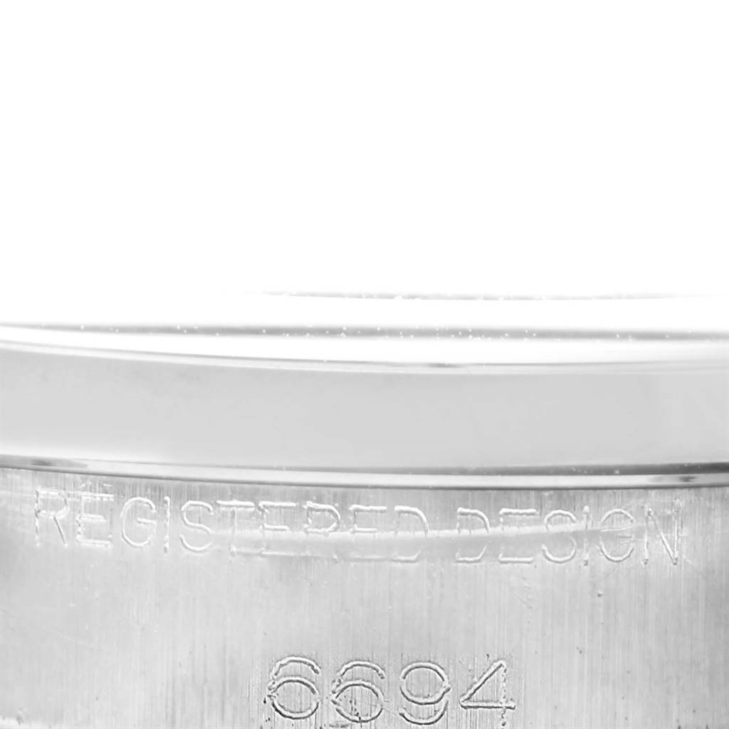 The image shows a close-up of the case back and edge of a Rolex Vintage Collection 6694 Men's Stainless Steel Silver Dial 6694 Men's Stainless Steel Silver Dial model 6694, highlighting the inscription.