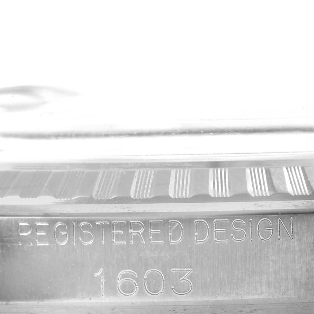 This close-up shot shows the side edge and markings of the Rolex Vintage Collection 1603 Men's Stainless Steel Silver Dial 1603 Men's Stainless Steel Silver Dial model, including "REGISTERED DESIGN" and "1603."