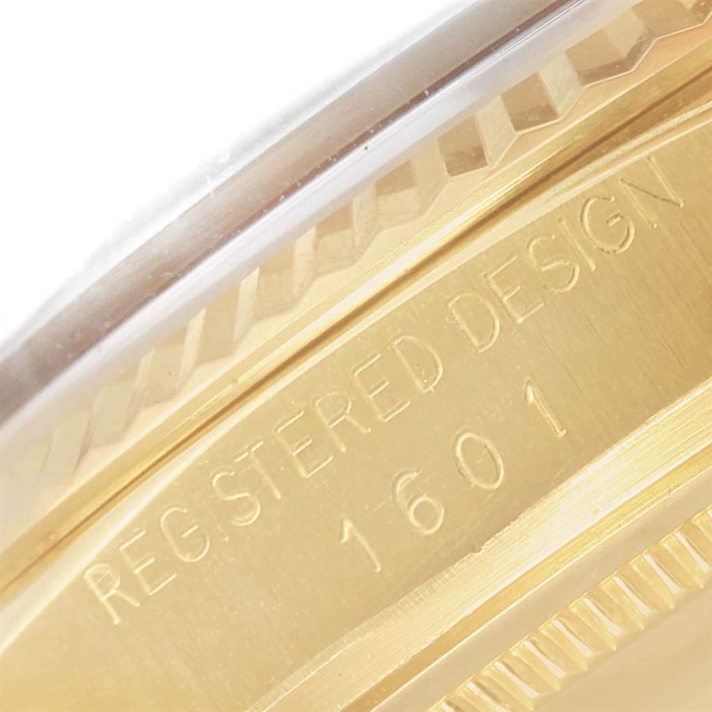The image shows a close-up of the side of the Rolex Vintage Collection 1601 Men's Yellow Gold Silver Dial 1601 Men's Yellow Gold Silver Dial model 1601 watch, highlighting the engraved "REGISTERED DESIGN" text.