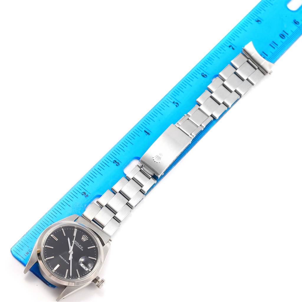 The image shows a Rolex Vintage Collection 6694 Men's Stainless Steel Black Dial 6694 Men's Stainless Steel Black Dial watch laid flat against a ruler, displaying its bracelet, clasp, and face.