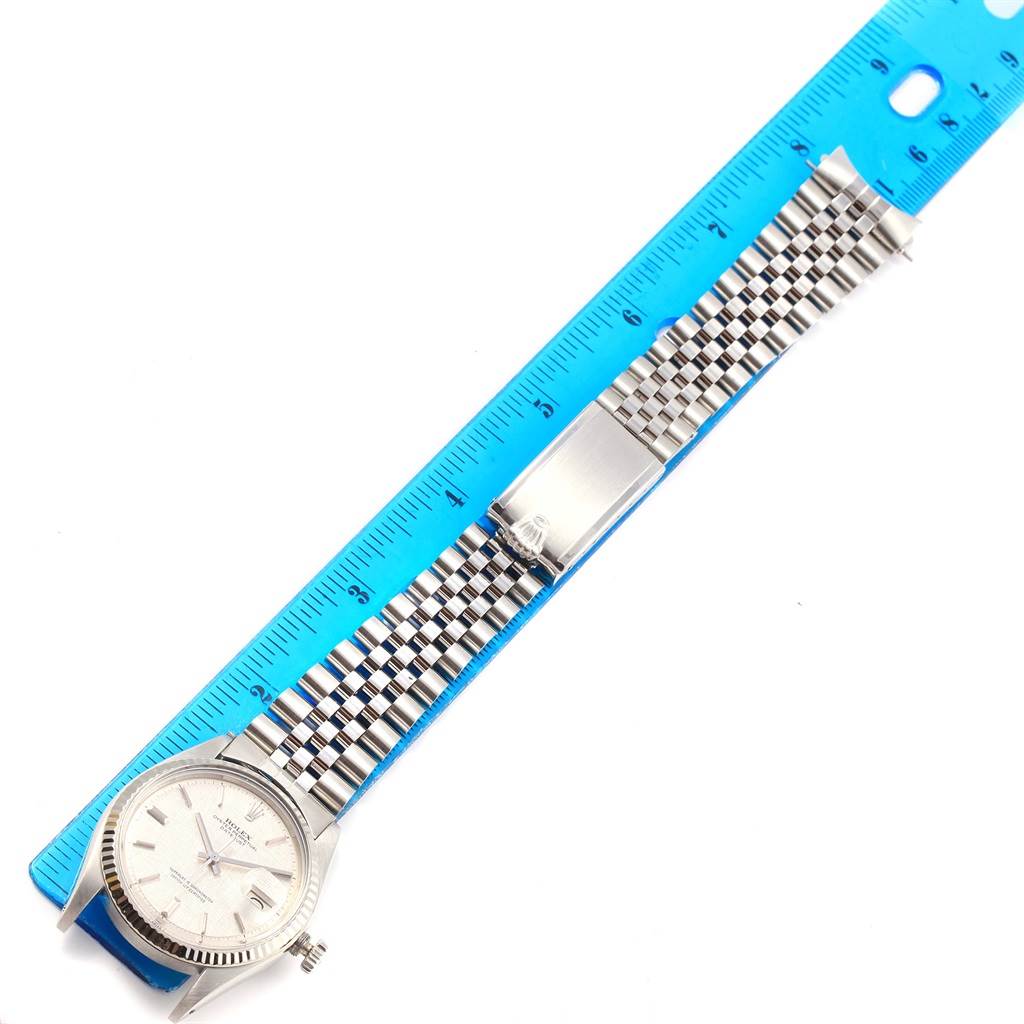 The Rolex Vintage Collection 1601 Men's Stainless Steel Silver Dial 1601 Men's Stainless Steel Silver Dial watch is shown flat from above, with its face, bezel, bracelet, and clasp visible alongside a ruler.