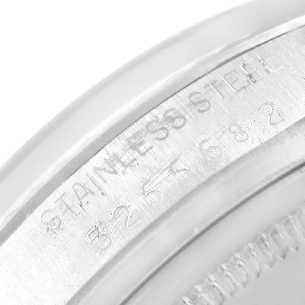 This image shows a macro shot of the stainless steel casing of a Vintage Collection Rolex watch, featuring engraved text.