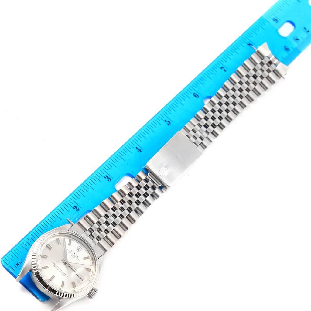 The image shows a Vintage Collection Rolex watch with a silver bracelet, viewed from the top with a blue ruler beside it.