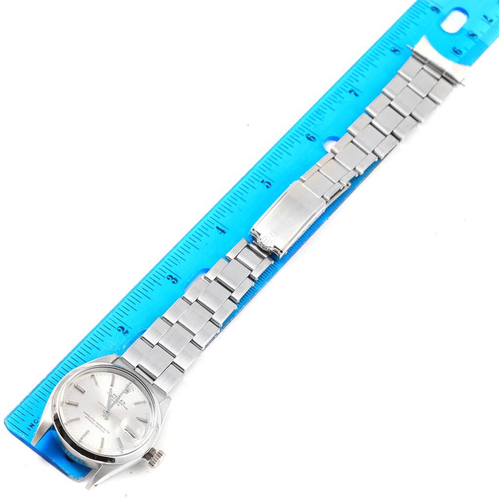 The Rolex Vintage Collection 1500 Men's Stainless Steel Silver Dial 1500 Men's Stainless Steel Silver Dial watch is shown in a flat lay with its face, bracelet, and part of the ruler for size reference.