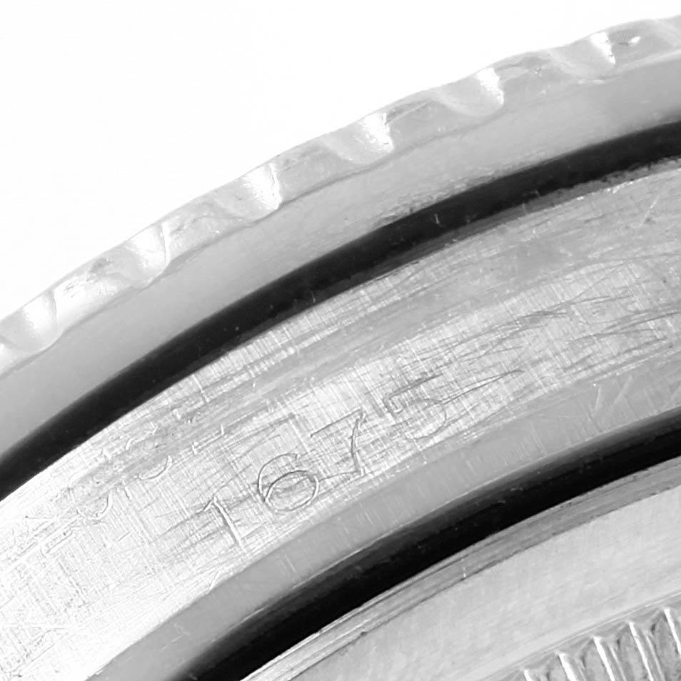 The image shows a close-up of the side of a Rolex Vintage Collection 1675 Men's Stainless Steel Black Dial 1675 Men's Stainless Steel Black Dial watch, highlighting the bezel and part of the case with an engraved model number.