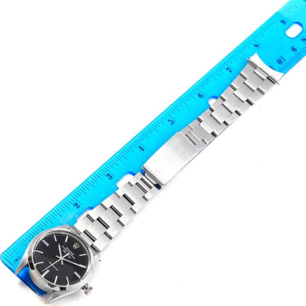 The image shows a Rolex Vintage Collection 5500 Men's Stainless Steel Black Dial 5500 Men's Stainless Steel Black Dial watch from a top-down angle, featuring its dial, bracelet, and a ruler for scale.