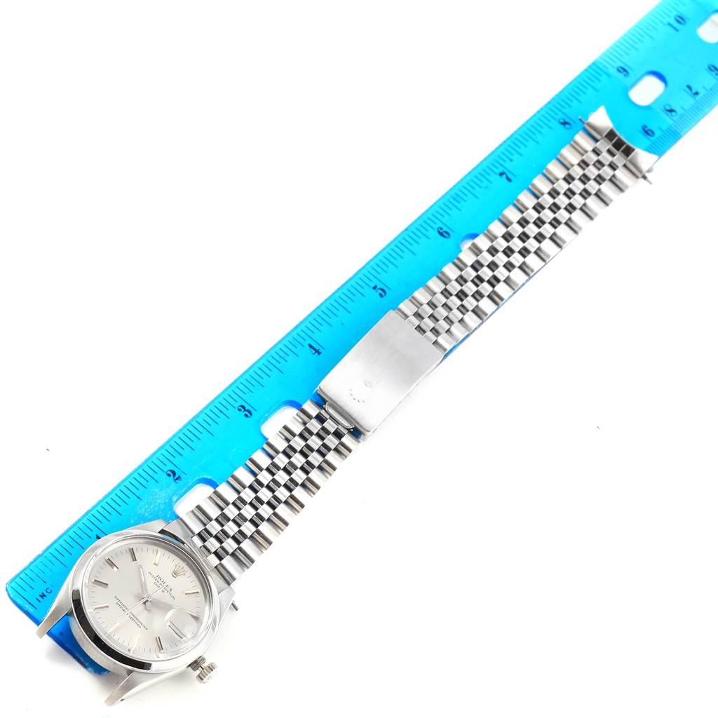 The Rolex Vintage Collection 15000 Men's Stainless Steel Silver Dial 15000 Men's Stainless Steel Silver Dial model watch is displayed flat, showing the face, crown, and stainless steel bracelet alongside a ruler.