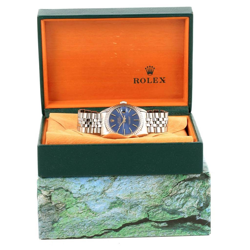 The Rolex Vintage Collection 16030 Men's Stainless Steel Blue Dial 16030 Men's Stainless Steel Blue Dial model watch is displayed head-on in an open green and orange box with a stone-textured outer layer.