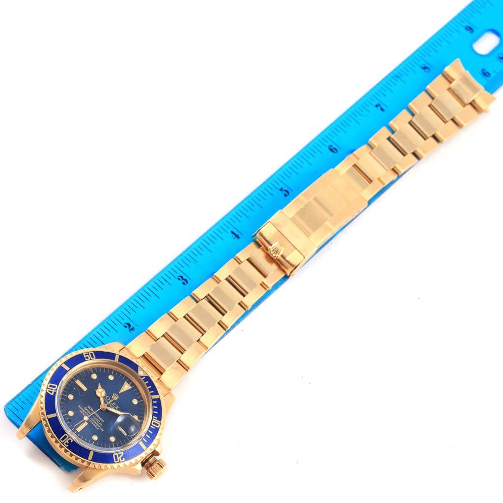 The Vintage Collection Rolex watch is shown from a top view, featuring its face, bezel, and bracelet against a ruler for scale.