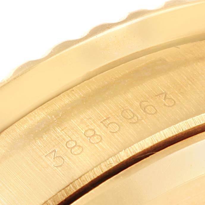 This close-up image shows the engraved serial number on the gold bezel of a Rolex Vintage Collection 1680 Men's Yellow Gold Blue Dial 1680 Men's Yellow Gold Blue Dial watch.