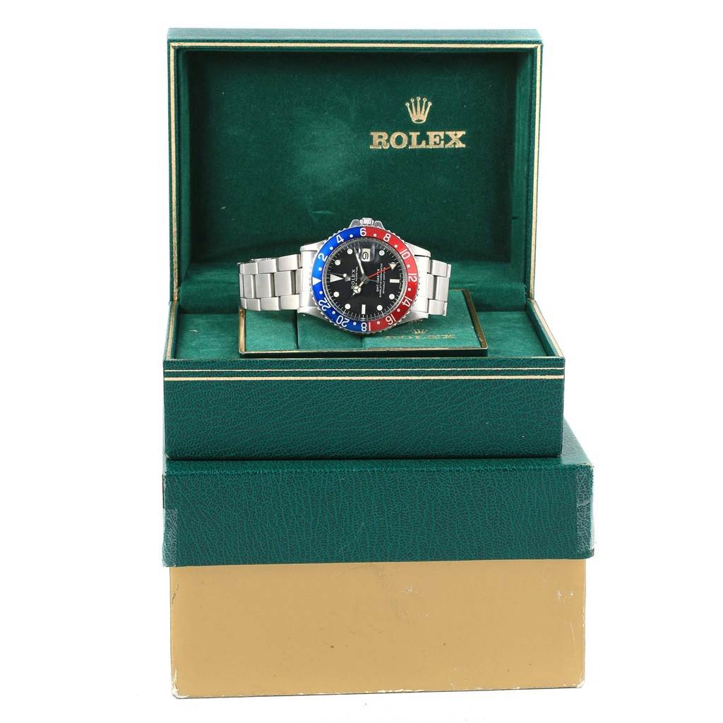 The image shows a front-angle view of a Rolex Vintage Collection 1675 Men's Stainless Steel Black Dial 1675 Men's Stainless Steel Black Dial watch with a red and blue bezel, inside its green box.