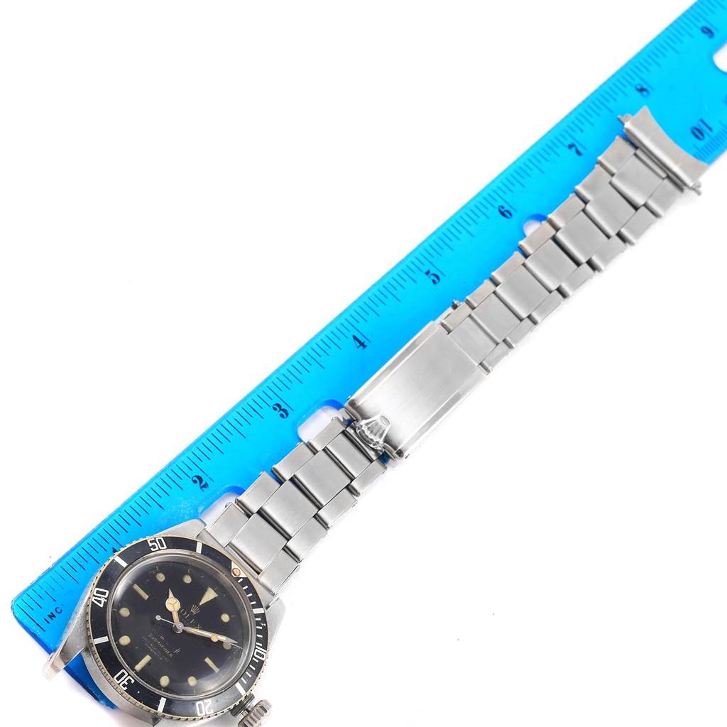 The image shows a Vintage Collection Rolex watch laid flat on a blue ruler for measurement.