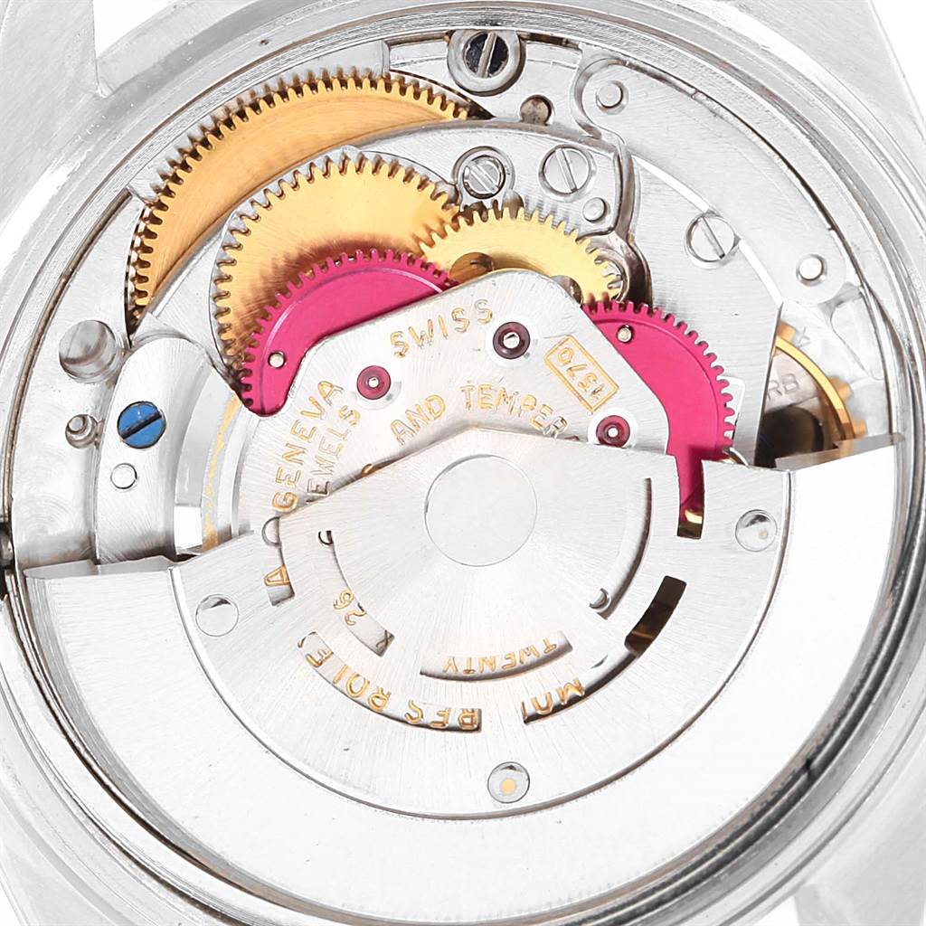The image shows a close-up of the internal movement mechanism of a Vintage Collection Rolex watch, including gears and other components.