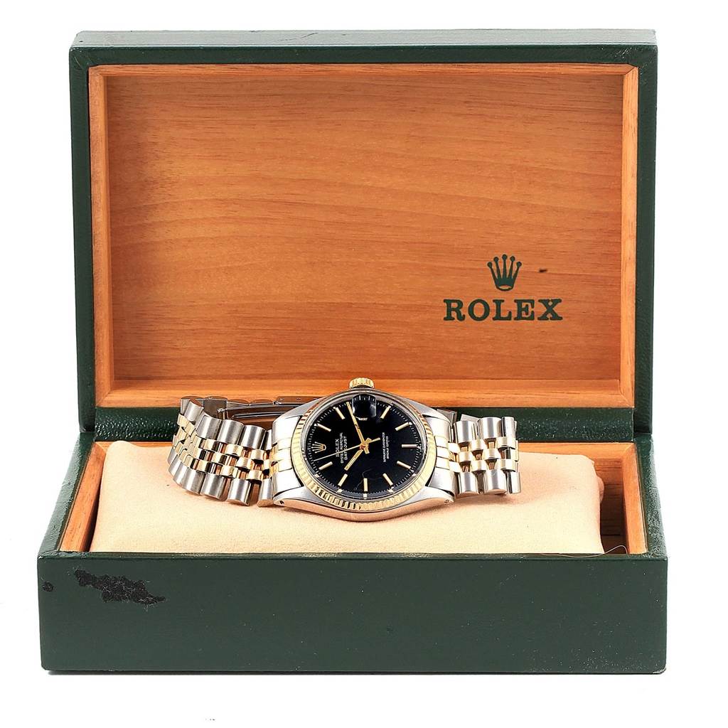 The watch, a Vintage Collection model by Rolex, is displayed face-up in a green and wooden Rolex box.