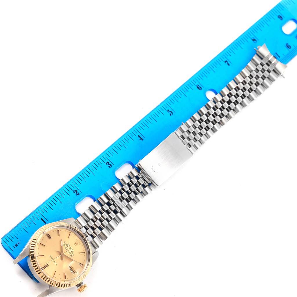 The image shows a Rolex Vintage Collection 5701 Men's Steel and Gold (two tone) Champagne Dial 5701 Men's Steel and Gold (two tone) Champagne Dial watch stretched out next to a blue ruler, highlighting its length and bracelet style.