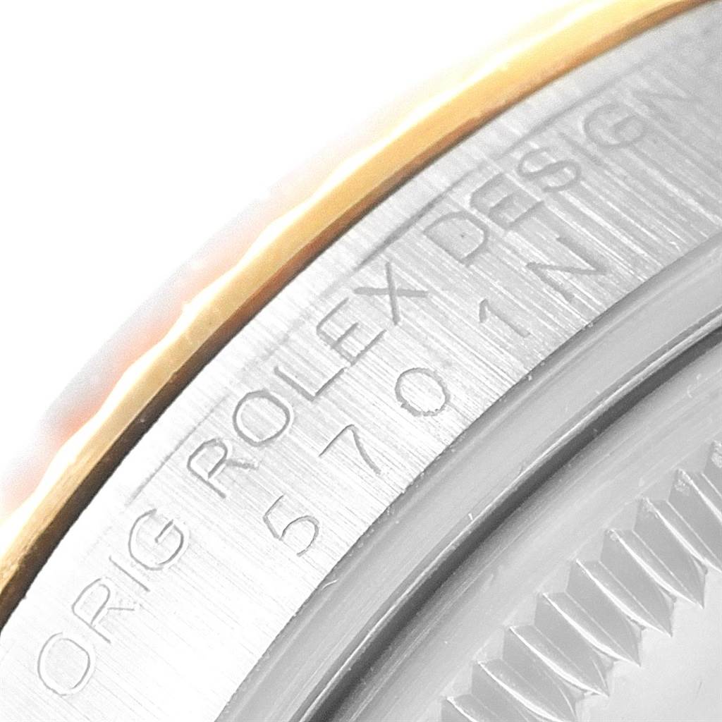 The image shows a close-up angle of the edge of a Rolex Vintage Collection 5701 Men's Steel and Gold (two tone) Champagne Dial 5701 Men's Steel and Gold (two tone) Champagne Dial model with the original design markings.